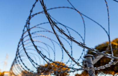 Close-up of barbed wire against sky