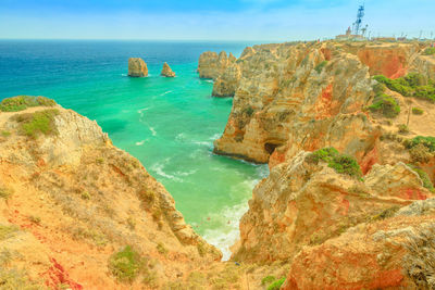 Scenic view of rocks in sea against sky