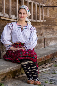 Portrait of young woman wearing traditional clothing while sitting on stairs