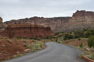 Road leading towards mountains against sky