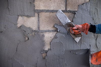 Cropped hands of worker plastering wall