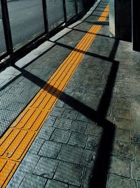 Shadow of railing on footpath