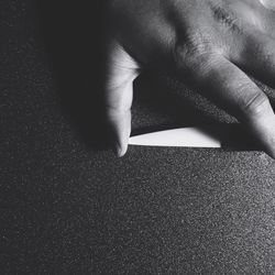 Cropped image of person holding knife on table