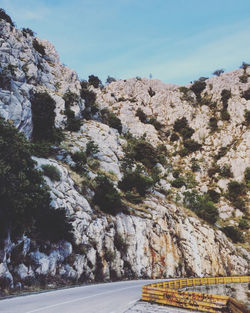 Road amidst rocky mountains against sky