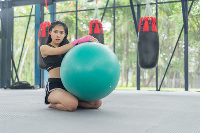 Young woman exercising on ball at gym