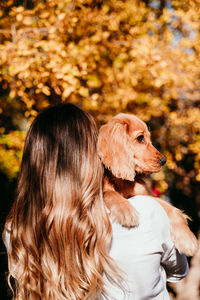 Rear view of woman with dog outdoors