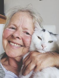 Close-up of woman with white cat at home