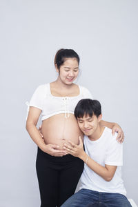 Happy friends standing against white background