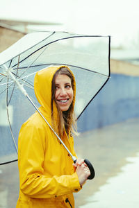 Woman looking away holding umbrella outdoors