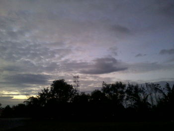 Silhouette of trees against cloudy sky