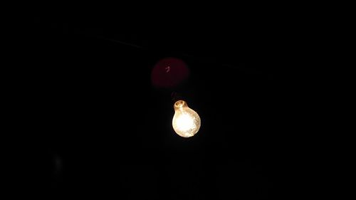 Close-up of illuminated lamp against black background