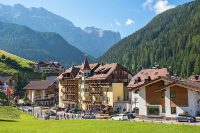 Houses by buildings against sky