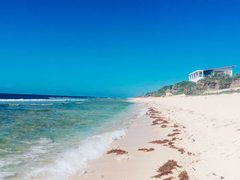 Scenic view of beach against clear blue sky