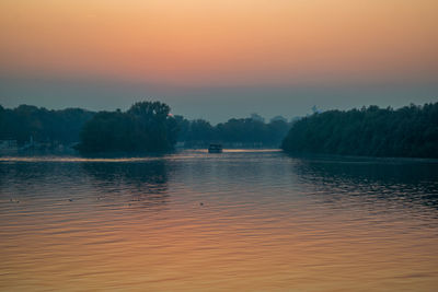 Scenic view of lake against orange sky