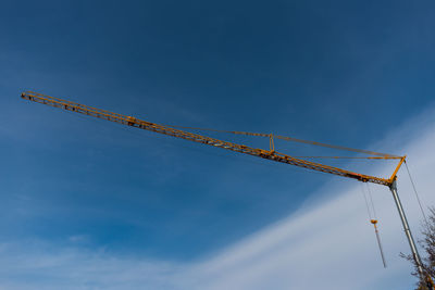 Low angle view of crane against blue sky