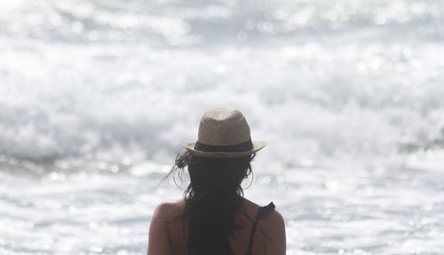Rear view of woman wearing hat against sea