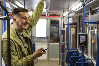 Man reading from mobile phone screen while traveling on metro. wireless internet on public transport