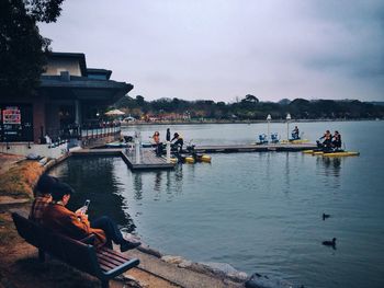 Side view of people boating in river