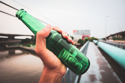 Close-up of hand holding beer bottle