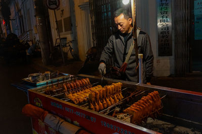 Man standing on barbecue grill at market