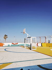 Low angle view of basketball hoop against clear blue sky