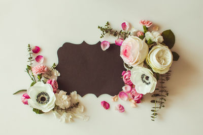 High angle view of pink roses on white table