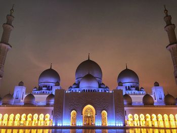 Illuminated building against sky