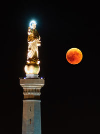 Low angle view of statue against sky at night