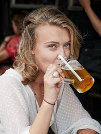 Portrait of a beautiful young woman drinking glass