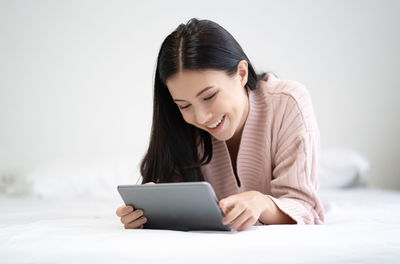 Smiling young woman using mobile phone