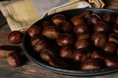 Close-up of roasted coffee beans in bowl on table