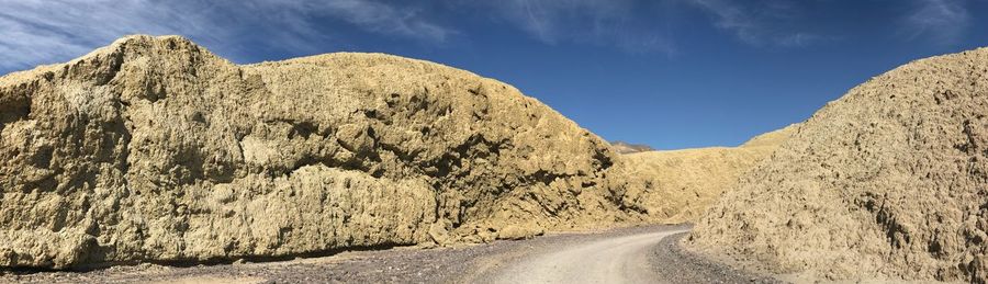 Panoramic view of road amidst rocks against sky