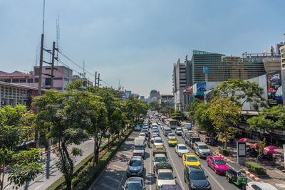 Traffic on city street by buildings against sky