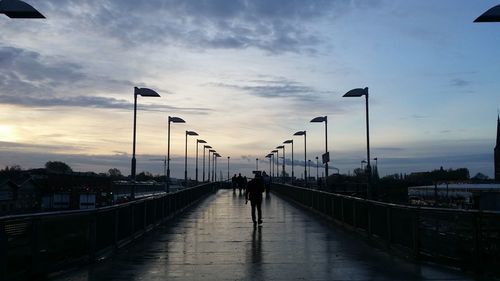 Pedestrian on road lined by street light