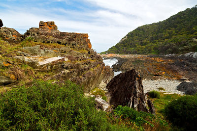 Rock formations by sea against sky