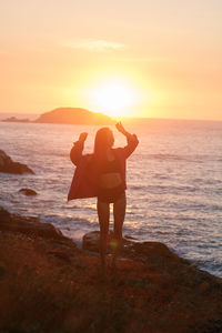 Full-length girl standing on the beach at sunset