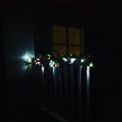 Low angle view of illuminated lighting equipment at night