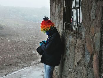 Midsection of woman with umbrella on snow against sky