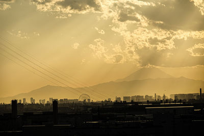 Silhouette buildings against sky during sunset