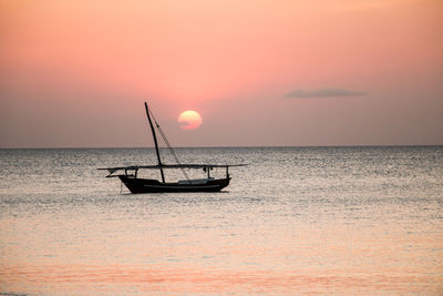 Silhouette boat in sea against sky during sunset