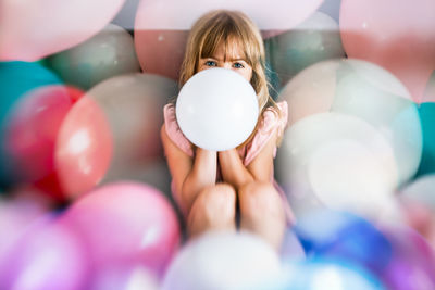 Birthday girl surrounded with balloons