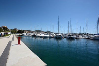 Boat in sea against clear blue sky