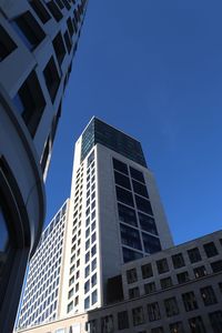 Low angle view of modern buildings against clear blue sky