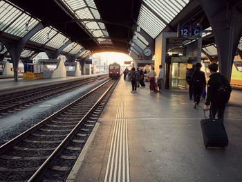 Rear view of people waiting on railroad station