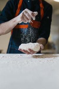 Midsection of man preparing food on table in kitchen