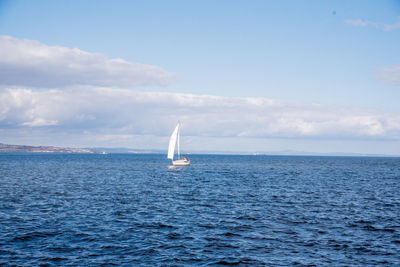 Sailboat sailing on sea against sky