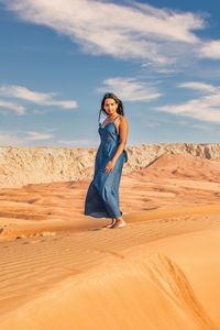 Young woman standing on sand at desert