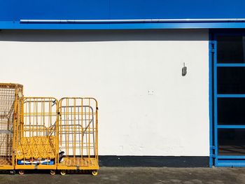 Yellow metal cart structure against white wall