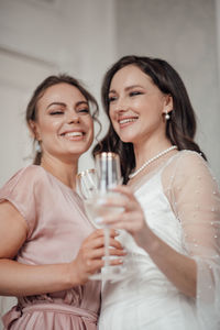 Portrait of a smiling young woman drinking glass