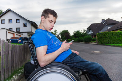 Disabled of man using mobile phone while sitting on wheelchair